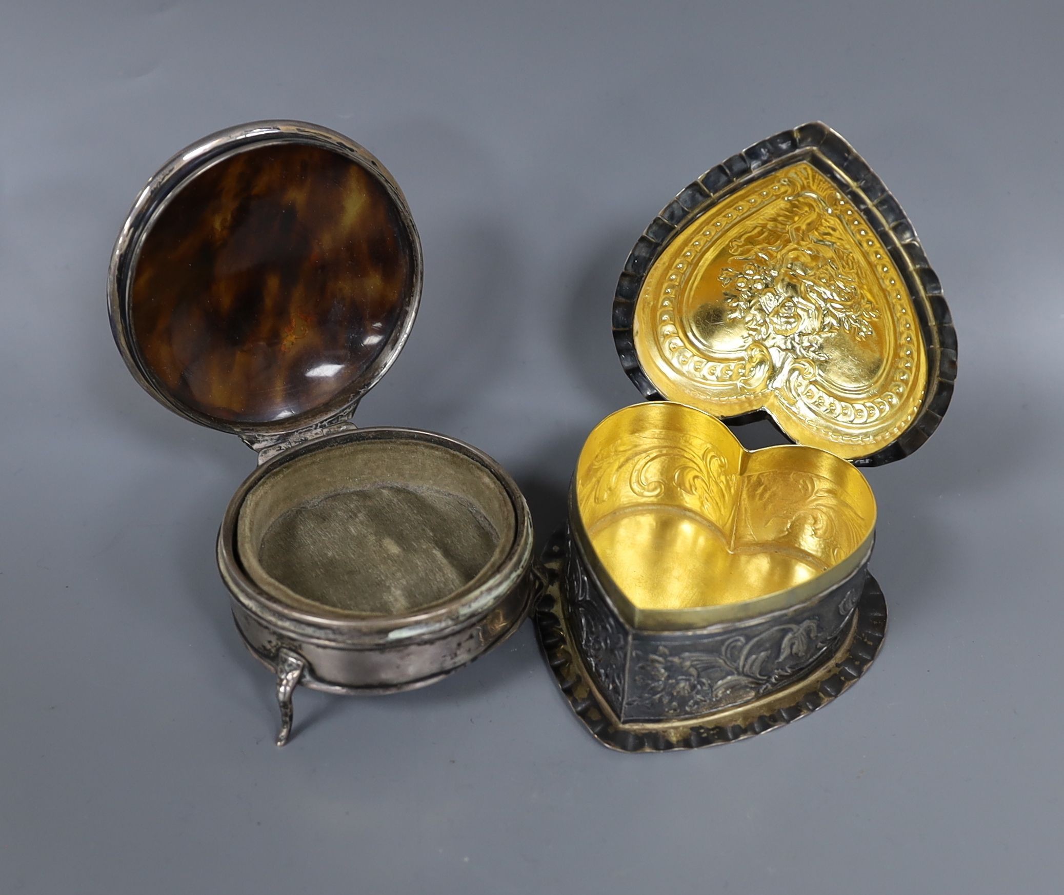 A George V silver and tortoiseshell pique circular trinket box, 71mm and a late Victorian embossed silver heart shaped box, import marks for London, 1888, 80mm.